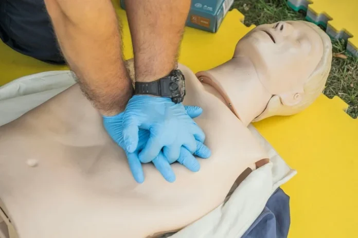 Healthcare provider performing chest compressions on a CPR manikin during ACLS certification renewal training.