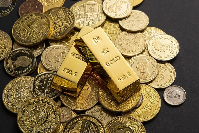 Gold bars surrounded by collectible coins, illustrating investment choices in precious metals.