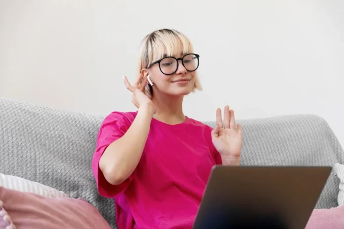 A woman using online hearing tests with earphones and a laptop to check her hearing at home.