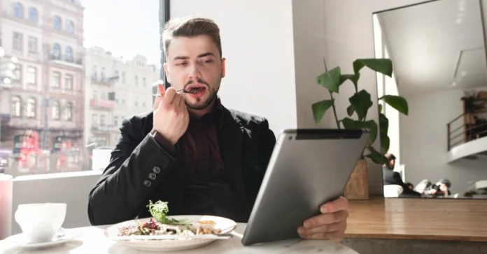 A woman checking her smartwatch and enjoying a healthy breakfast, illustrating How to Sync Your Eating Window for better daily routines.